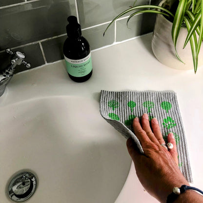 woman wiping sink with reusable swedish compostable dish cloth