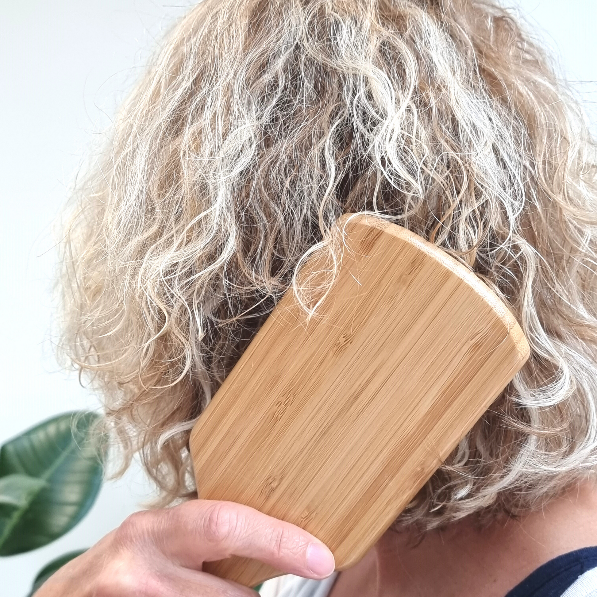 woman brushing hair with ecojiko bamboo hair paddle brush